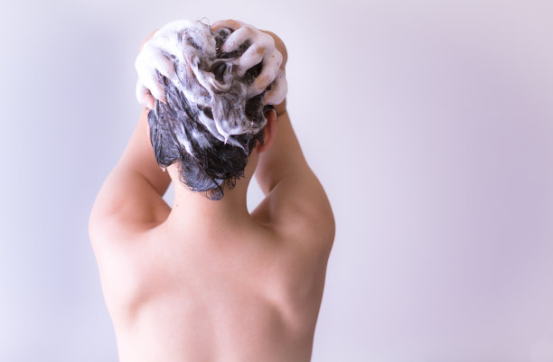 一个在淋浴间洗头发的性感女人。图片下载