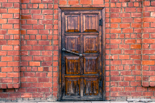 在砖墙上有矩形形状的旧木门。图片下载