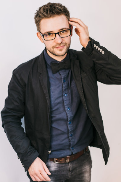 一个年轻人的肖像靠在灰色的墙上图片下载