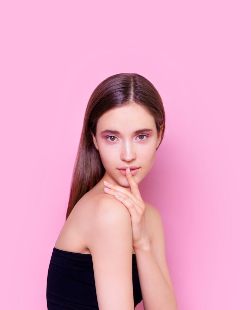 美丽的黑发年轻女人与容光焕发的粉红色背景时尚模特特写美镜头图片下载
