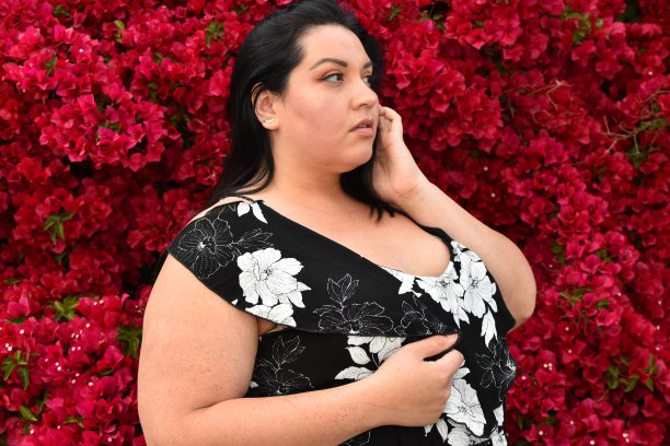 年轻的女人在印花与三角梅向上看图片下载