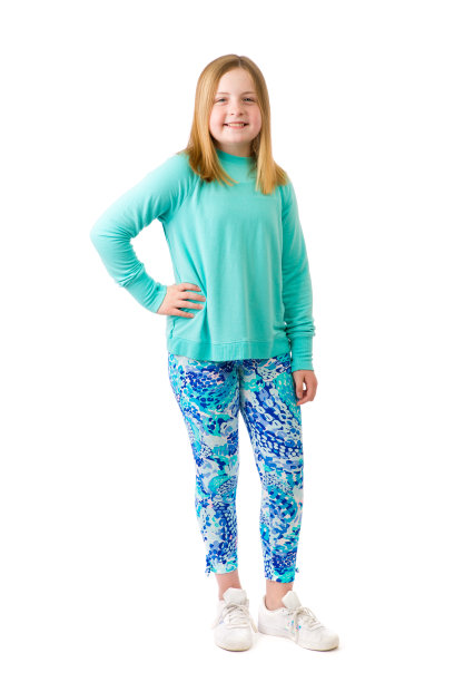 一个年轻的少女坐在地板上白色背景的全长肖像图片下载