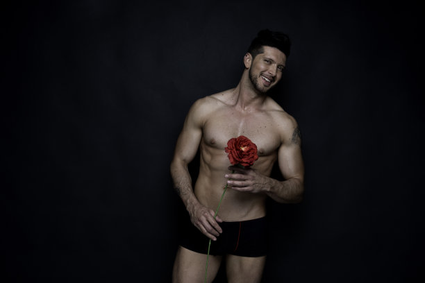 英俊的男子站在黑色背景前图片下载