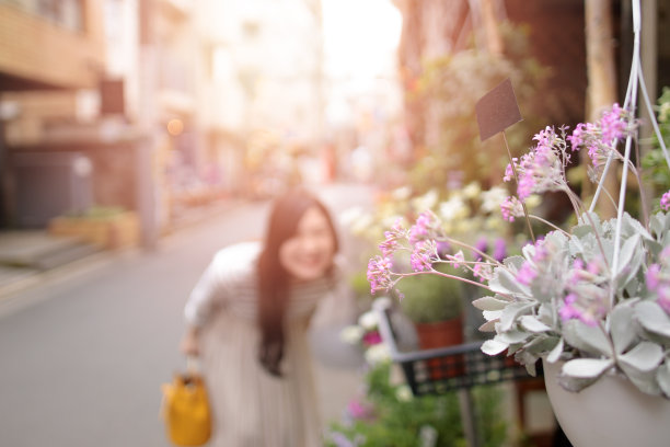 年轻女子在花后微笑图片下载