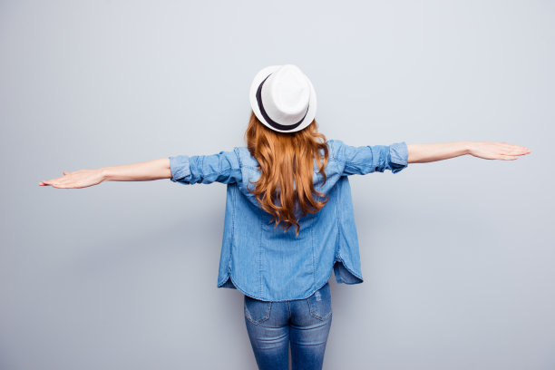 近距离的后面，后面，照片美丽的，她，她，她的女士，旅行者，观察美妙的风景，发现最好的方式，城市，城镇展开双臂像翅膀，穿着眼镜，休闲牛仔裤，牛仔衬衫孤立的灰色背景图片下载