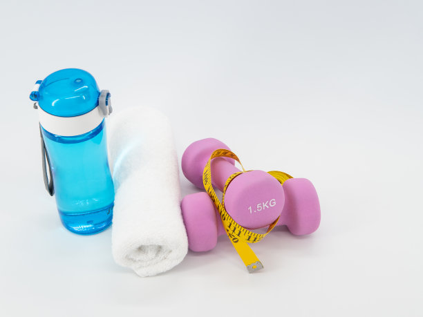 健身设备与哑铃，饮水机和毛巾隔离在一个白色的背景。健康与运动理念。图片下载