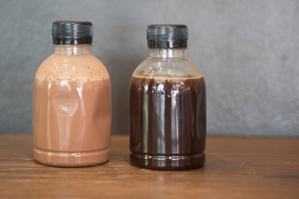 木制桌子上的塑料咖啡瓶-冷萃咖啡和摩卡咖啡图片下载