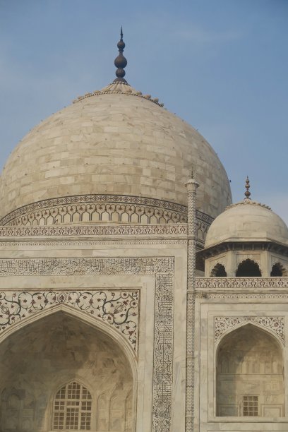 阿格拉莫卧儿泰姬陵陵墓的特写，在日出的黄金时刻，白色大理石建筑立面，镶嵌着半珍贵的“印度之星”宝石，尖塔和洋葱圆顶，泰姬陵照片壁纸与蓝天背景图片下载