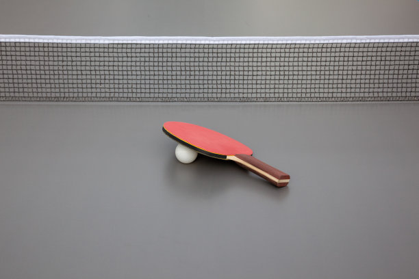 灰色的乒乓球台，带球拍和球图片下载
