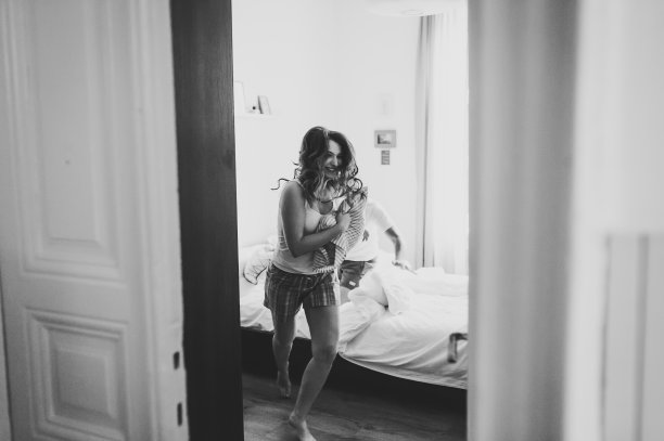 女人从她丈夫身边跑进屋。情侣胜过枕头。幸福的情绪美丽的年轻夫妇。享受在一起的时光。的生活方式。黑白照片。图片下载