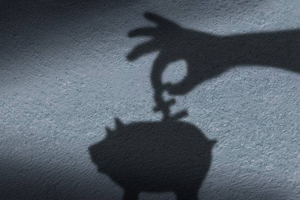 把硬币放进存钱罐的手的影子。图片下载