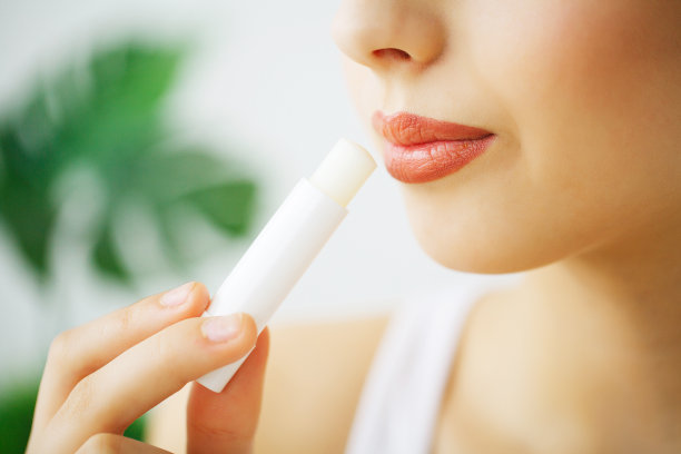 快乐的笑年轻女人完美的皮肤，自然的化妆和美丽的微笑。女性肖像与裸露的肩膀在一个灰色的背景图片下载