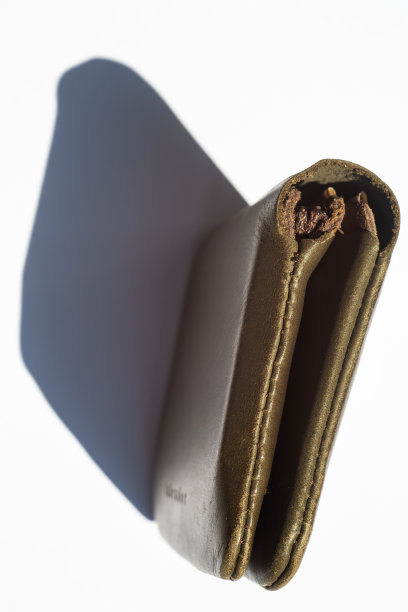 皮夹子上的钱在白色背景，光和阴影，近距离和微距拍摄图片下载