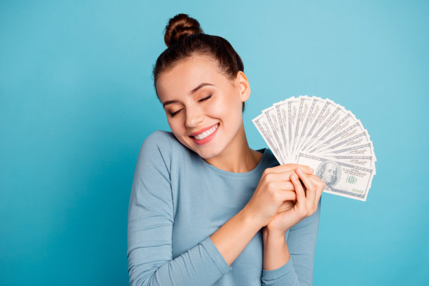 漂亮可爱的青少年的近距离照片少年启发有兴趣的深思的未来购买运气幸运的赢家赌场美元闭上眼睛握着手穿着时尚的时髦的服装孤立在蓝色的背景图片下载