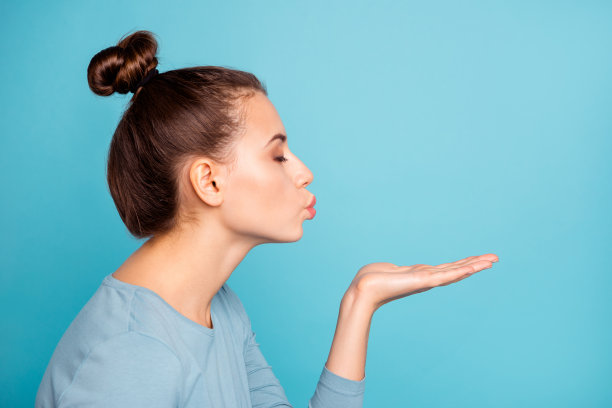 个人资料侧视图照片优雅华丽温柔的女士送吻吸引男朋友闭上眼睛感到满意高兴平静握着手穿着时尚的青年服装孤立在蓝色的背景图片下载