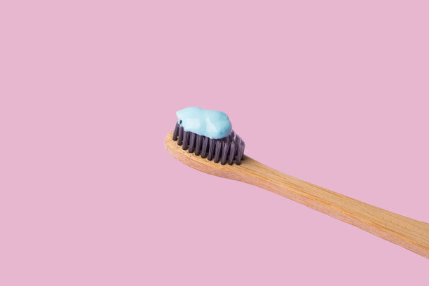 用蓝色牙膏涂在粉色上的牙刷图片下载