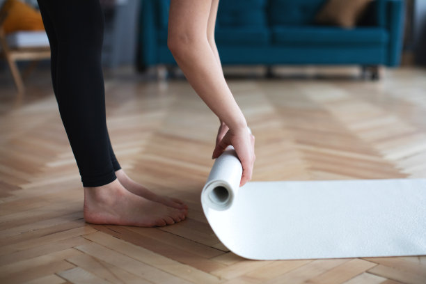 近女子双手展开的垫子正在准备在家健身。图片下载