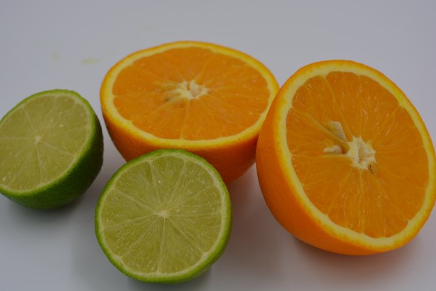 鲜亮的两半橙子，熟透多汁的橙子和酸橙。健康的食物和水果，健康和运动。图片下载