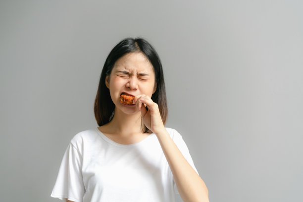 快乐的女人拿着炸鸡吃。图片下载