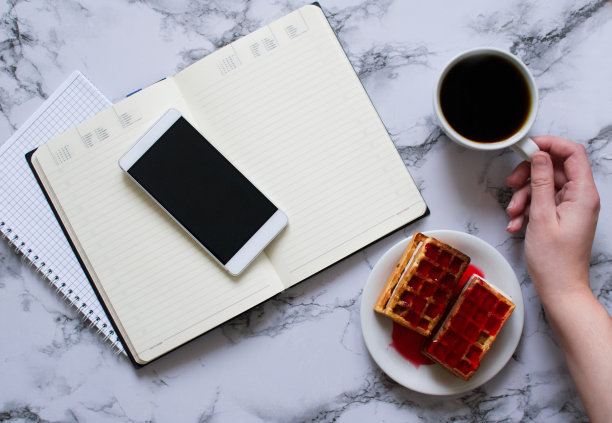 女人的手，一杯咖啡，一天计划，商务午餐和智能手机图片下载