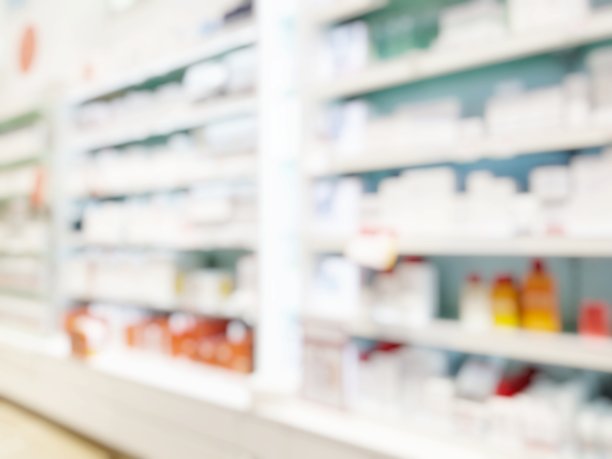 模糊抽象背景药房与客户。药店和药剂师视野模糊。模糊干净的药房与药品架上。散焦白色药店。图片下载