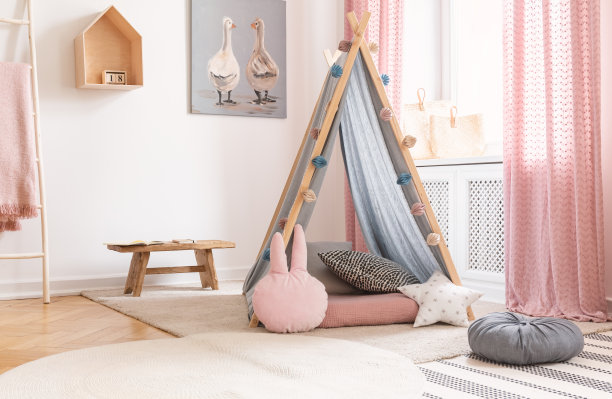 这是一个粉红色的儿童游戏室，里面有帐篷、油画和木凳图片下载