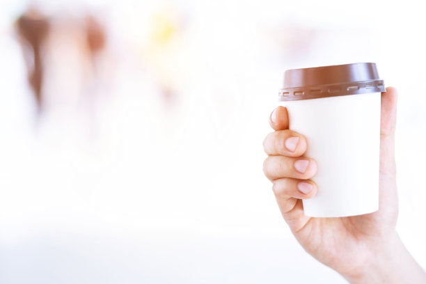 商人手拿纸杯带走喝咖啡在自然的早晨阳光。空格你的文字或标志的位置。图片下载