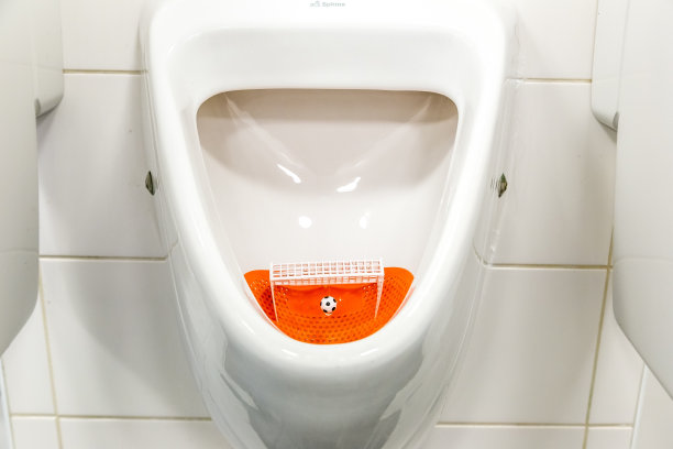 荷兰奇怪而独特的小便池(厕所)。小便器带有足球球门和足球。尿壶打靶练习足球足球进球图片下载