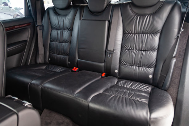 清洗一辆昂贵的suv内部的哑光黑色真皮后座后，准备出售汽车。汽车服务行业。详细说明清洗。图片下载