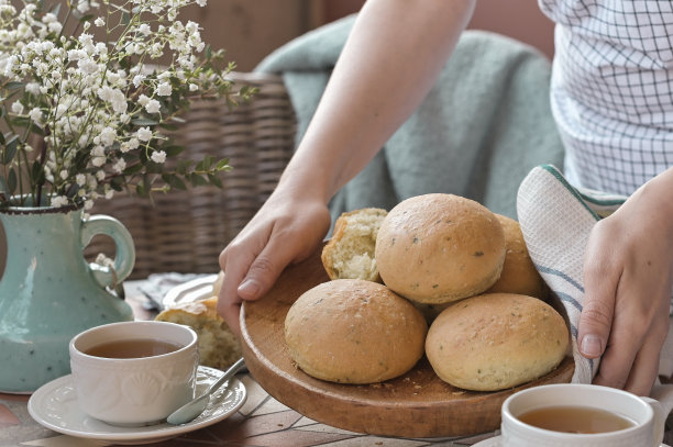 一个女人手里拿着罗勒自制的汉堡面包。供早餐和茶用。生活的照片图片下载