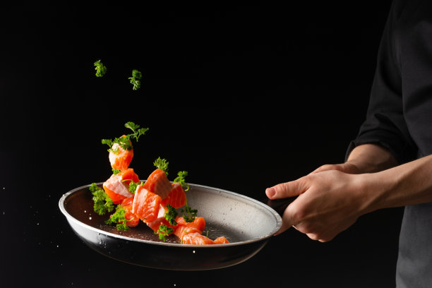 海鲜，烹饪鲑鱼与蔬菜，在一个黑暗的背景，横向照片，健康和健康的食物，冻结在空气中图片下载