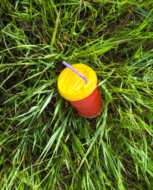 塑料杯放在草地上图片下载