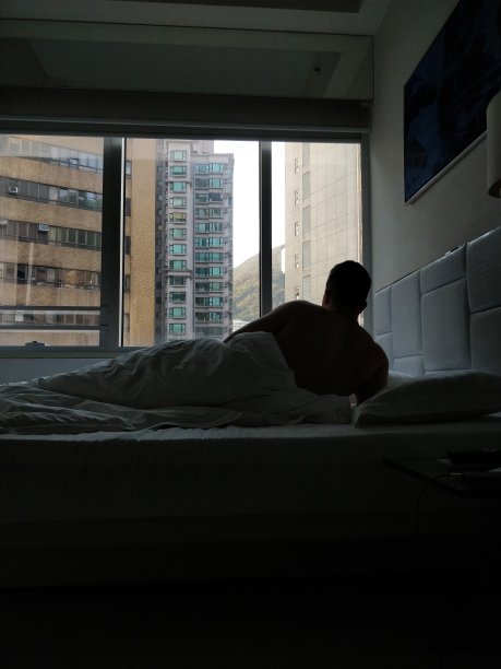 香港，床上男人望着窗外图片下载
