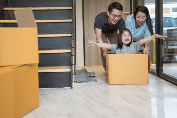 一个快乐的亚洲家庭带着纸箱搬到新家。图片下载
