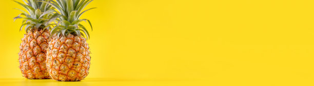 美丽新鲜的菠萝孤立在明亮的黄色背景上，夏季季节性的水果设计理念图案概念，复制空间，近距离图片下载