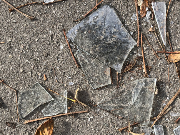 散落在柏油路上的碎玻璃散落在秋叶间图片下载