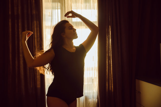 穿着内裤的年轻性感女人早上拉开窗帘图片下载