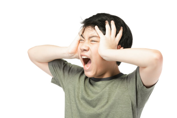 肖像年轻的亚洲男孩在灰色的背景，沮丧;有一个坏脾气的情绪少年的肖像穿t恤。有思想的少年，被孤立在白色的背景下。图片下载