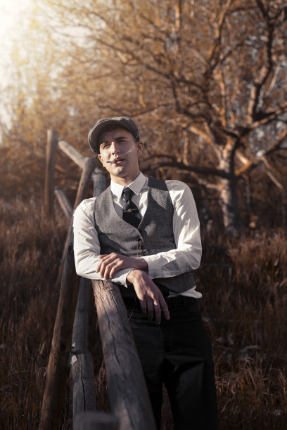 近距离观察日落时分在自然公园里吸烟的年轻男子图片下载