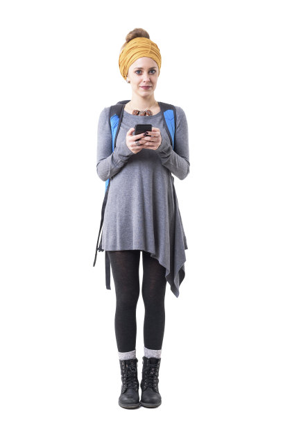 年轻时尚的女性游客与头巾和背包使用手机看相机。图片下载