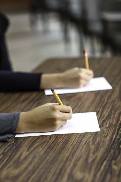 在教室里，女性在书桌上写字图片下载