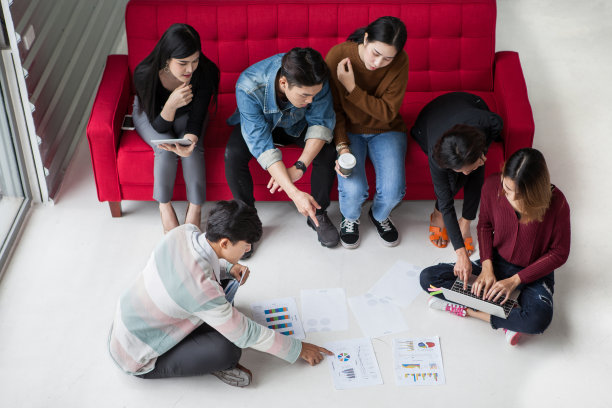 大学生团队头脑风暴。年轻的商业人士开始团队会议坐在地板和红色的沙发图片下载