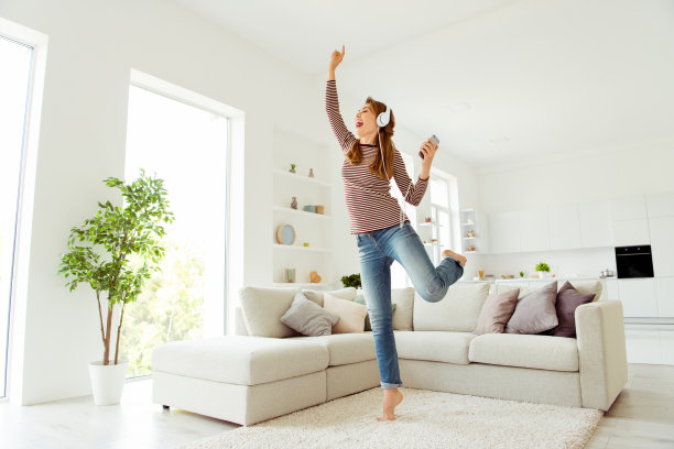 近距离的照片美丽的她她的女士手臂手拿电话读单词歌曲耳罩耳朵非常高兴时髦的穿着牛仔裤牛仔条纹套头衫衣服明亮舒适的公寓房子客厅在室内图片下载