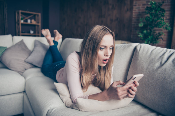 特写照片的漂亮她她的夫人用盯着眼睛用手拿着现代科技设备小玩意躺在枕头柔软的沙发上图片下载