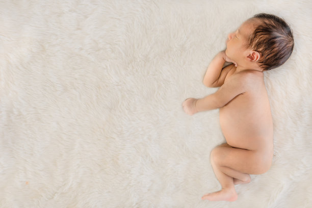可爱的亚洲婴儿睡在白色的地毯上图片下载