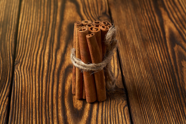 一束肉桂用绳子绑在木制的背景上。图片下载