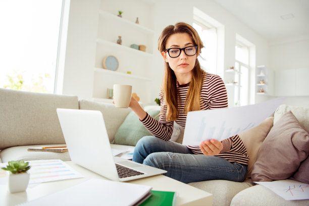 近距离的照片美丽的她，她的模特女士手，手臂，抱着纸学生考试，热茶饮料，细心，穿牛仔裤，牛仔条纹套衫，衣服，坐舒适舒适的沙发，房子，客厅，室内图片下载