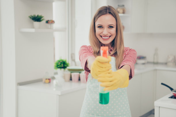 特写照片美丽的好职责她她的夫人站在闪亮的白色明亮的厨房房子完成的工作拿洗涤剂像枪玩游戏大笑穿休闲牛仔裤牛仔衬衫围裙平坦的室内图片下载
