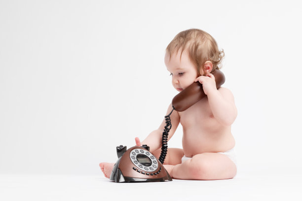 可爱的婴儿玩旧电话图片下载