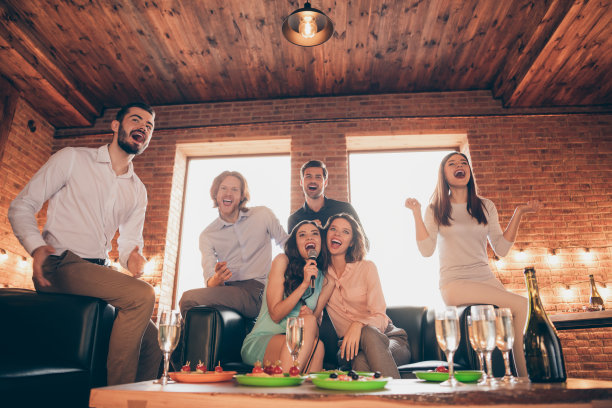 近距离的照片卡拉ok夜活动公司出去休息放松唱歌她她的女士他他他的男人酒杯金色的饮料礼服衬衫正装坐沙发阁楼房间室内图片下载